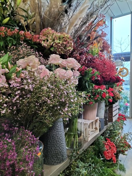 Vaste sélection de fleurs colorées et feuillage dans une boutique florale.